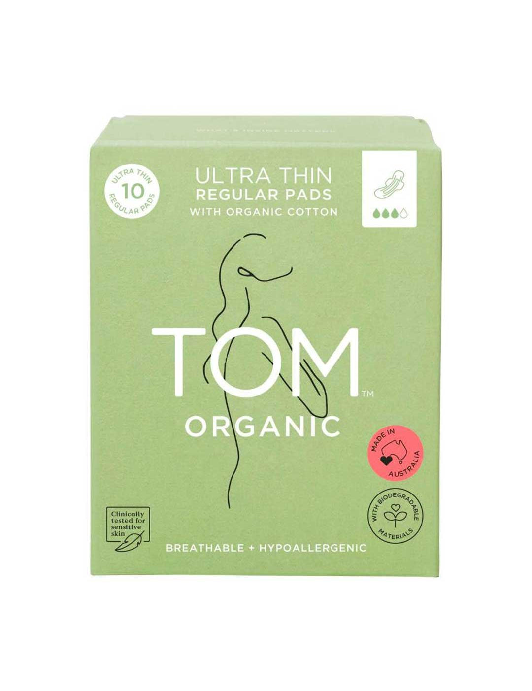 A green box of TOM Organic Pads Regular 10pk, made with organic cotton, features a minimalist woman line drawing, highlights hypoallergenic and biodegradable pads, and displays a pink certified organic label.