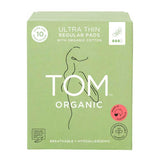 A green box of TOM Organic Pads Regular 10pk, made with organic cotton, features a minimalist woman line drawing, highlights hypoallergenic and biodegradable pads, and displays a pink certified organic label.