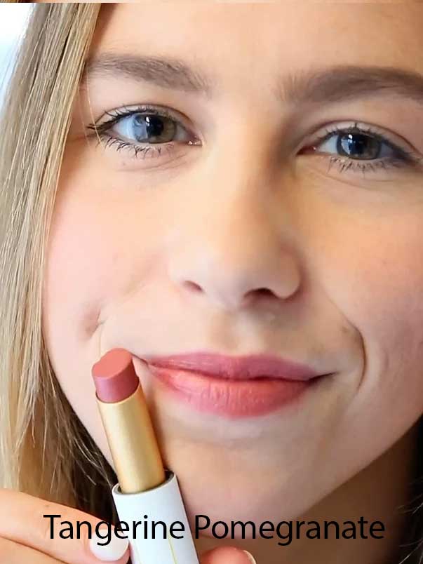 A smiling person holds a tube of Luk Beautifood Lip Nourish Lipsticks 3g in a pink shade near their lips. "Tangerine Pomegranate" appears at the bottom of the image.