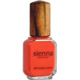 A bottle of Sienna Byron Bay Nail Polish - Tango, a toxin-free, bright tangerine orange shade, shown in clear glass with a wooden cap and visible front label.