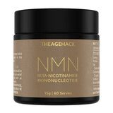 Small amber The Age Hack NMN powder jar with a broad black screw lid and a gold-brown label, with large thin gold 'NMN' lettering above the full ingredient name.