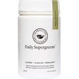 A white container labeled The Beauty Chef Daily Supergreens Inner Beauty Support Apple 150g, with a green tag. This powder supports cleansing, alkalizing, and rebalancing with apple flavor, fiber, digestive enzymes, and probiotics for gut health.