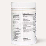 A white plastic jar labeled "The Beauty Chef GUT PRIMER+® 140g" with a white cap features text highlighting GutGard for abdominal bloating relief and a nutrition panel listing gut health powder ingredients. The background is light beige.