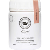 A white jar of The Beauty Chef Glow® 150g berry-flavored supernutrient powder for gut health, skin, and wellness. It features black text and a pink lid tag reading "IT'S A GUT THING," promoting glowing skin.