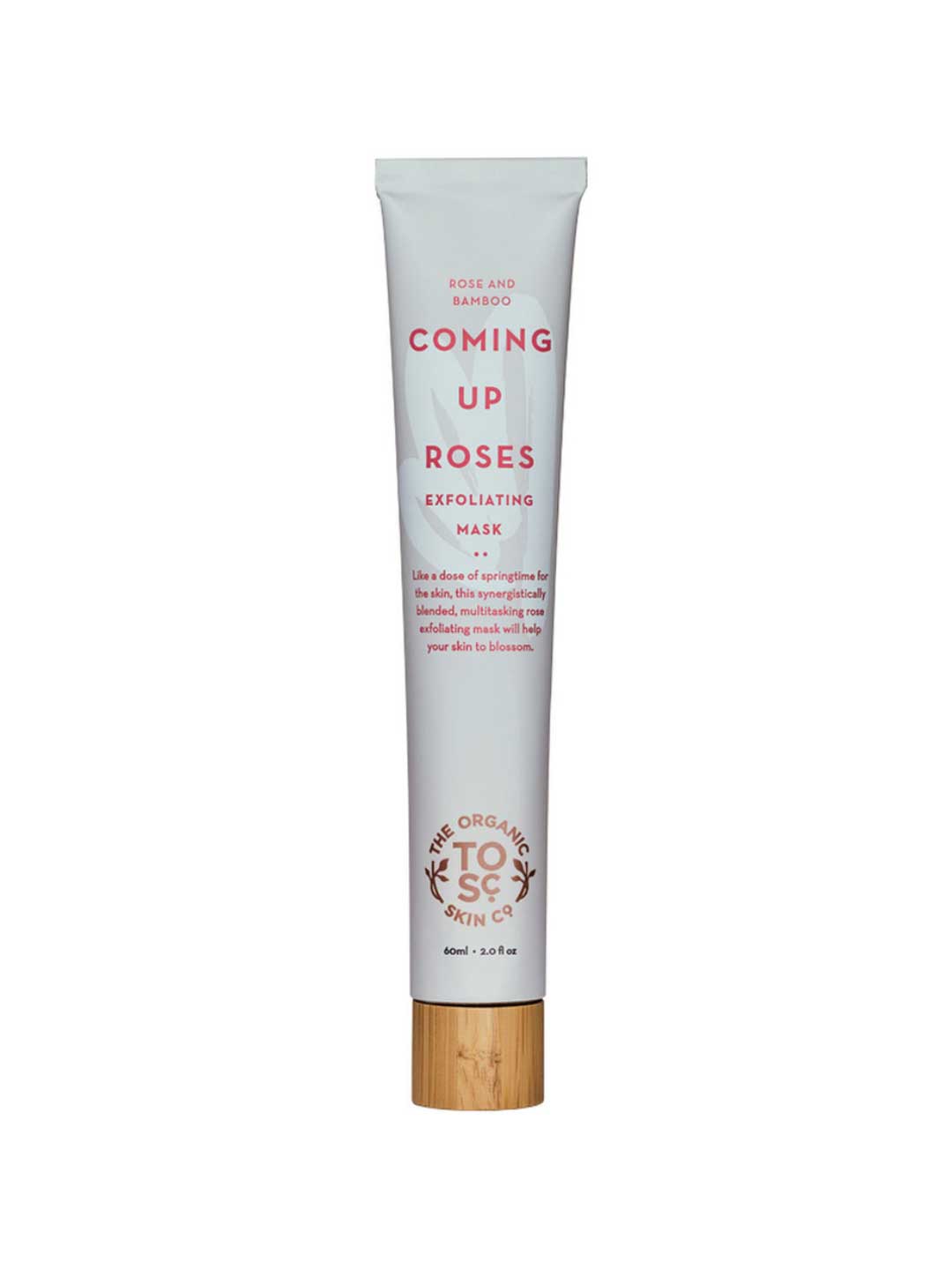 A white tube of The Organic Skin Co Coming Up Roses Exfoliating Mask 60ml, with pink text and a wooden cap, contains rose and bamboo stem extract. The label highlights this organic exfoliating mask.