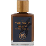 A 30ml bottle of The Organic Skin Co The Only Glow Tinted Face Oil - Deep, featuring a wooden cap and dark label with gold text, delivers organic tinted face oil for a luminous complexion.