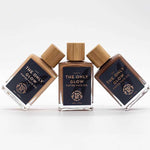 Three bottles of The Organic Skin Co The Only Glow Tinted Face Oil - Deep 30ml stand upright and slightly tilted on a white background, featuring dark labels, wooden caps, and an organic formula for a radiant complexion.