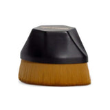 The Three Warriors Beauty Buff Brush features dense brown bristles and a short, rounded black handle for streak-free self-tan application. Shown against a white background, it’s perfect as a self-tan applicator.