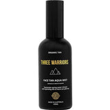 Three Warriors Face Tan Aqua Mist 100ml comes in a black bottle with gold and white branding, featuring a geometric logo. This vegan, organic face tan mist provides a natural-looking glow and is made in Australia.
