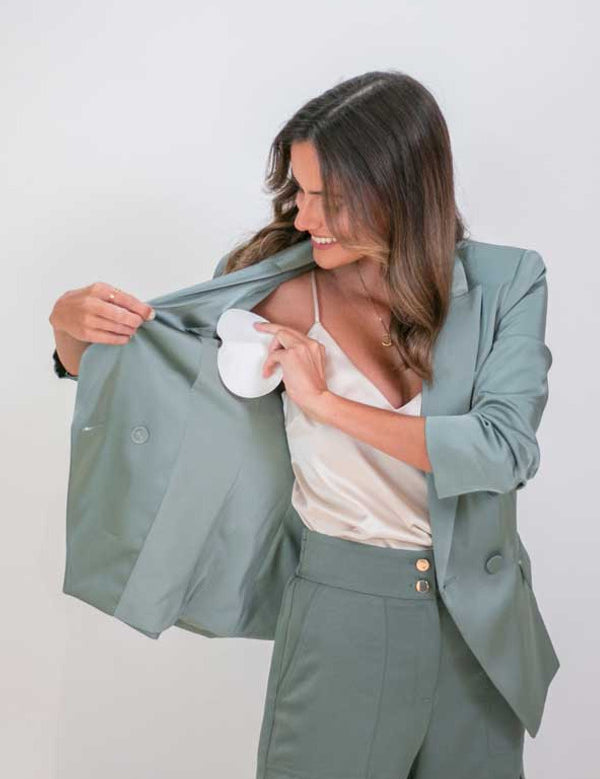 Woman demonstrating an UnderWunder perspiration protector inside her blazer