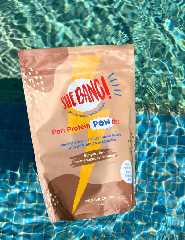 She BANG! Milk Chocolate Peri Protein POWder pouch beside a swimming pool