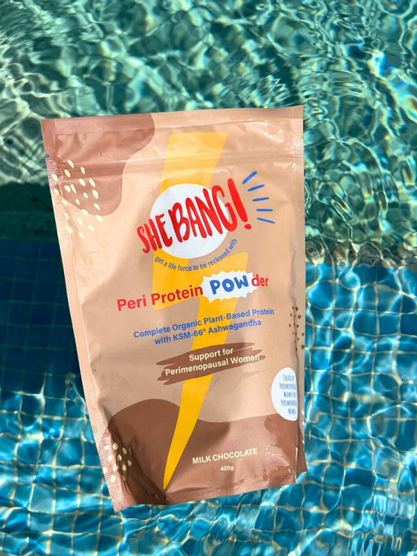 She BANG! Milk Chocolate Peri Protein POWder pouch beside a swimming pool