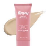 A pink tube of RAWW Vitamin C BB Cream 30ml stands before a beige smear, showcasing its creamy texture. Infused with argan oil and chia seed, this hydrating beauty balm promotes a luminous complexion.
