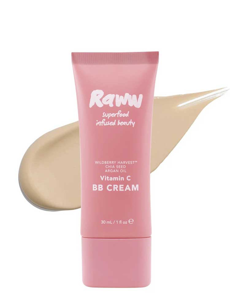 A pink tube of RAWW Vitamin C BB Cream 30ml stands before a beige smear, showcasing its creamy texture. Infused with argan oil and chia seed, this hydrating beauty balm promotes a luminous complexion.