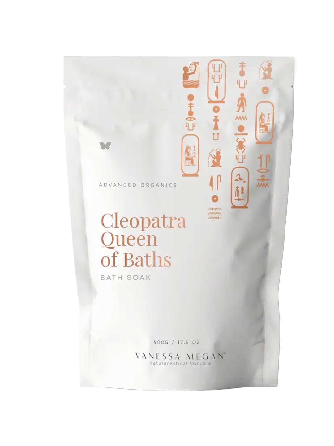 A white pouch labeled Vanessa Megan Cleopatra Queen of Baths Bath Soak/Scrub with gold Egyptian-style symbols. This 500g vegan milk bath soak, from their advanced organics line, is designed for radiant skin.