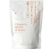 A white pouch labeled Vanessa Megan Cleopatra Queen of Baths Bath Soak/Scrub with gold Egyptian-style symbols. This 500g vegan milk bath soak, from their advanced organics line, is designed for radiant skin.