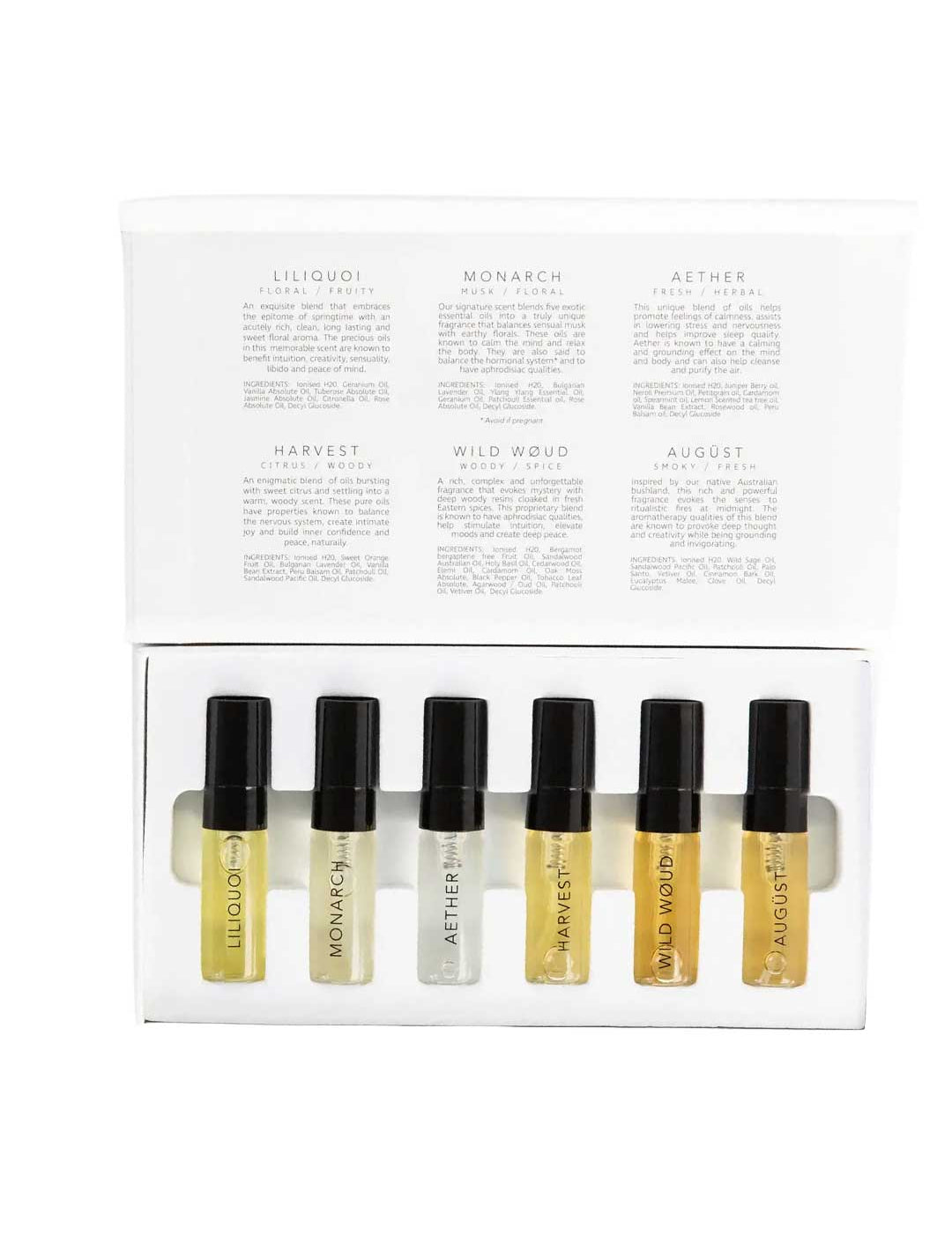 The Vanessa Megan 100% Natural Mini Eau de Parfum Collection (6 x 3ml) features six labeled vials with black caps in a white box. The inside lid lists scent descriptions, including a natural white-floral fragrance. All vials are neatly arranged in a row.