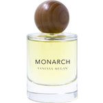 The Vanessa Megan Monarch 100% Natural Eau de Parfum 50ml features a clear glass bottle with yellow liquid and a round wooden cap, showcasing an elegant, floral-musk scent crafted with clean perfumery principles.