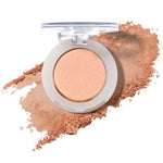 The 100% Pure Fruit Pigmented® Eye Shadow 2g by 100% Pure is a round beige pressed powder compact with a clear lid, displayed open on a smear of powder—ideal for those seeking vegan pressed eyeshadow.