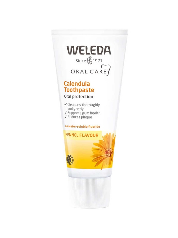 White Weleda Calendula Toothpaste tube with a yellow band marked Fennel Flavour, an orange flower illustration and a white cap.