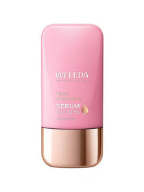 Weleda Glow Perfecting Serum Drops in a flat pink bottle with rounded corners, a reflective rose-gold base cap and a small gold droplet symbol.