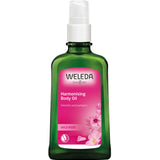 Weleda Harmonising Wild Rose Body Oil 100ml comes in a green bottle with a white pump and pink label adorned with wild rose flowers—ideal for anyone seeking nourishing, natural body oil.