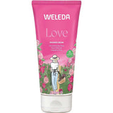 A pink tube of Weleda Love Shower Cream - Rose (200ml) features a woman in a white hat and dress with a basket in a rose garden. This body wash contains natural damask rose essence.
