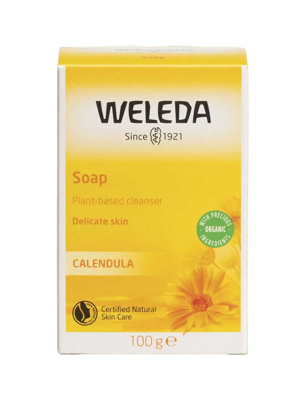 A yellow and white box of Weleda Soap Bar Calendula 100g for sensitive skin, with a sunflower graphic, certification logos, and text highlighting its organic, plant-based ingredients.