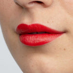 A close-up of lips wearing Antipodes Moisture Boost Natural Lipsticks 4g in a vibrant red shade, showing smooth skin. "West Coast Sunset" appears at the bottom of the image.