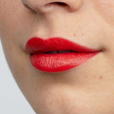 A close-up of lips wearing Antipodes Moisture Boost Natural Lipsticks 4g in a vibrant red shade, showing smooth skin. "West Coast Sunset" appears at the bottom of the image.