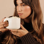 Woman sipping Nutra Naturals Collagen White Hot Chocolate Salted Caramel