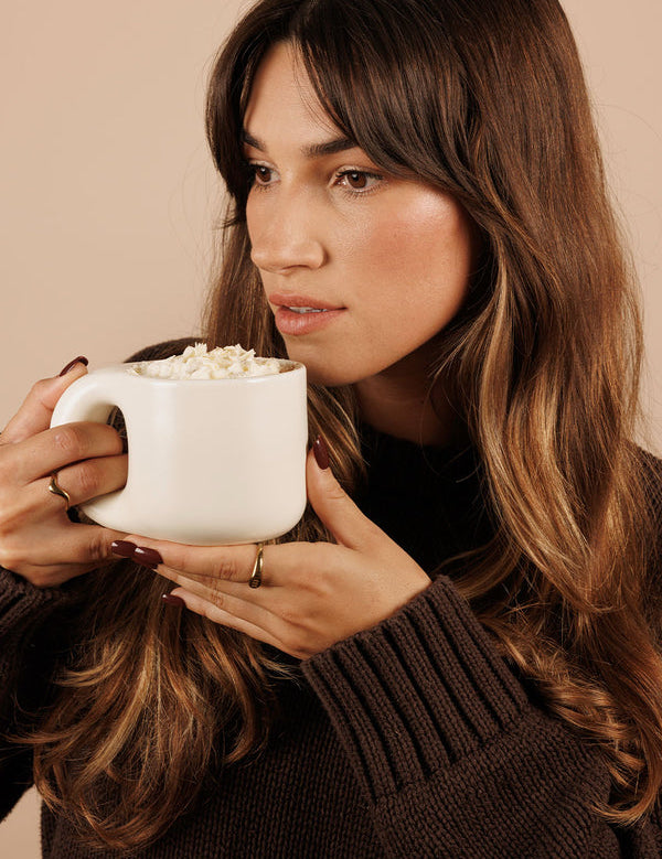 Woman sipping Nutra Naturals Collagen White Hot Chocolate Salted Caramel