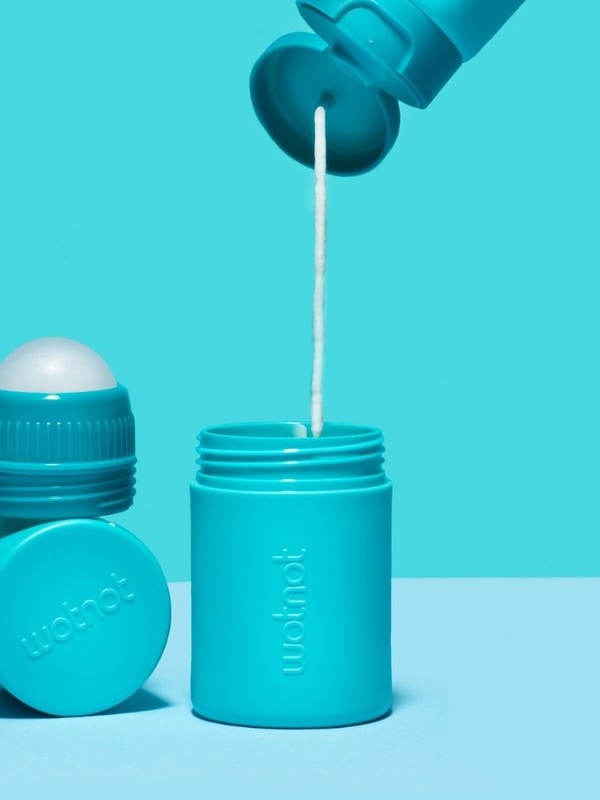 Wotnot refillable sunscreen roll-on applicator being applied to skin
