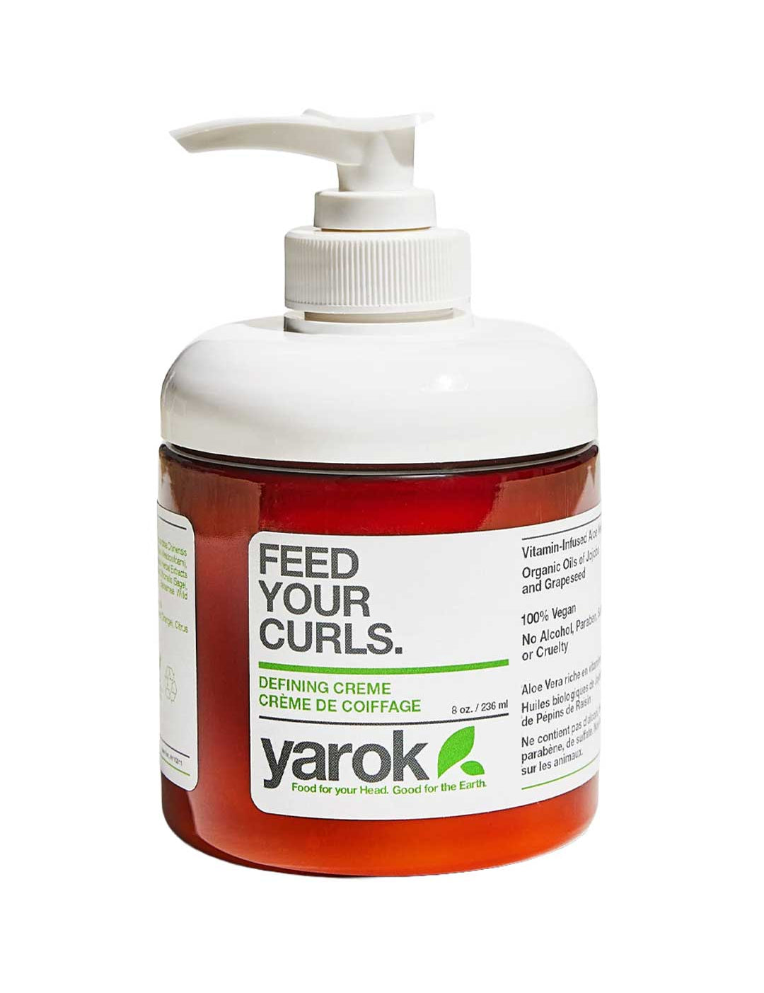 A bottle of Yarok Defining Creme on a white background, featuring a white pump dispenser, a translucent white cap, and a white label with green and black text over a reddish-brown bottle body.