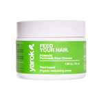 A white plastic jar of Yarok Feed Your Hair Pomade with a bright green label, set against a plain white background.