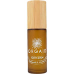 A 36ml brown glass bottle of Orgaid Youth Serum Hyaluronic and Vitamin C with a wooden cap, featuring a flower graphic label. This vitamin C serum blend helps brighten skin.