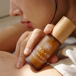 Woman holding Orgaid Youth Serum beside her face