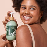 A bit Hippy Face and Body Cleanser held by a smiling woman