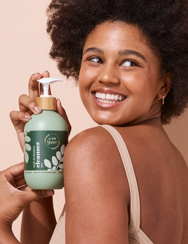 A bit Hippy Face and Body Cleanser held by a smiling woman