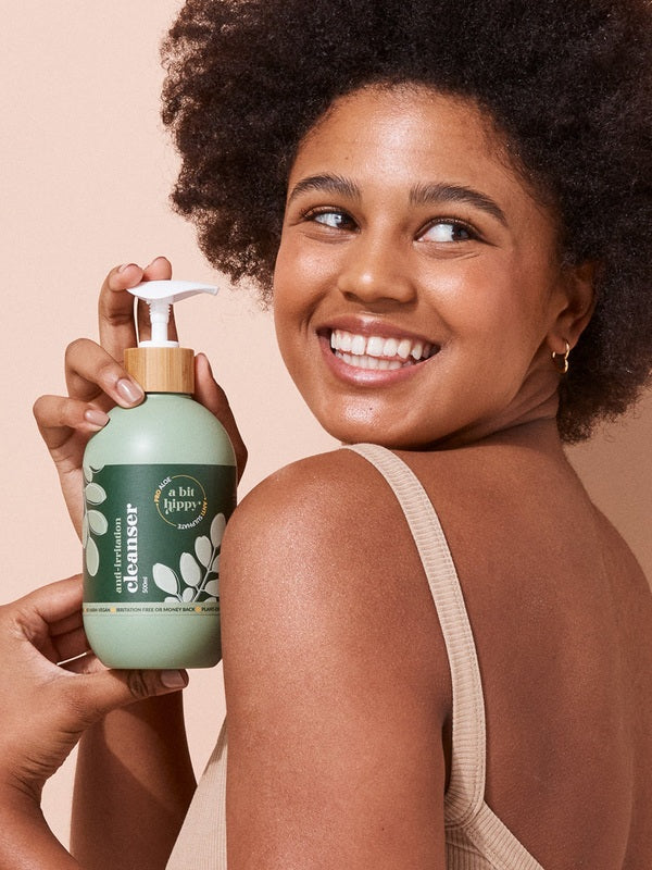 A bit Hippy Face and Body Cleanser held by a smiling woman