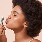 A bit Hippy Coconut and Lime SPF 15 Lip Balm held to the lips