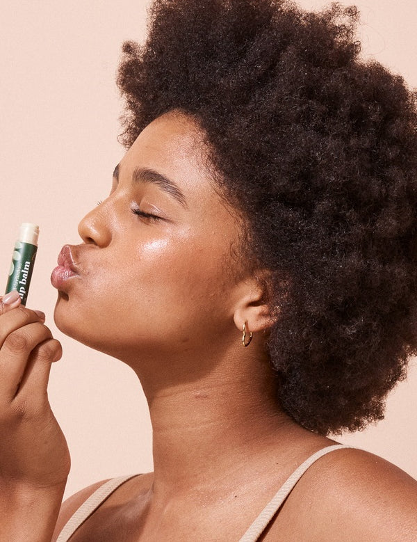 A bit Hippy Coconut and Lime SPF 15 Lip Balm held to the lips