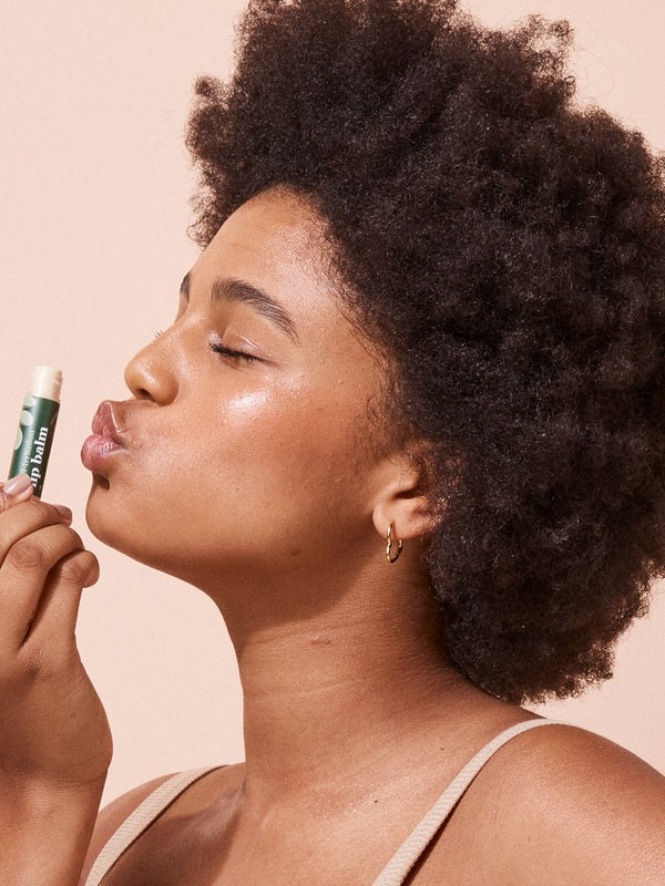 A bit Hippy Coconut and Lime SPF 15 Lip Balm held to the lips