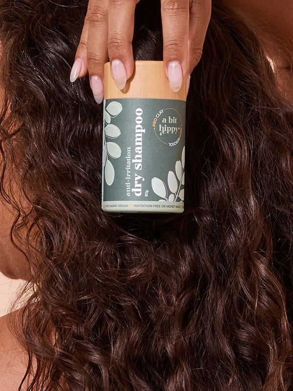 A bit Hippy Dry Shampoo held against curly hair