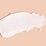 A broad white swatch of A bit Hippy Face Cream spread horizontally on peach, with a smooth centre, a rounded left end and an uneven, tapered right edge.