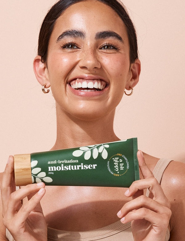 A bit Hippy Face and Body Moisturiser held by a smiling woman