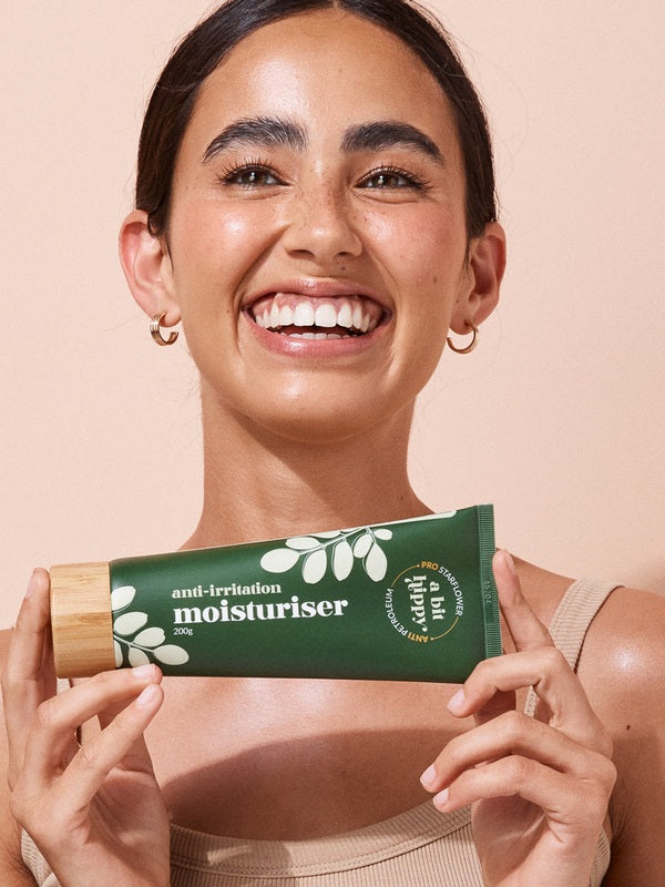 A bit Hippy Face and Body Moisturiser held by a smiling woman
