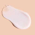 A smooth, pale pink-white swatch of A bit Hippy Night Cream on peach, shaped like a teardrop with a rounded end and a thin, slightly ragged tip.