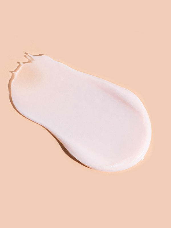 A smooth, pale pink-white swatch of A bit Hippy Night Cream on peach, shaped like a teardrop with a rounded end and a thin, slightly ragged tip.