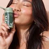 A bit Hippy Powder Exfoliant held beside a smiling woman's face